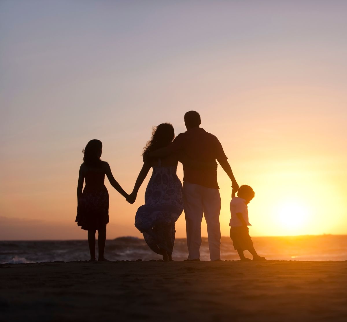 A family silhouetted together at sunset